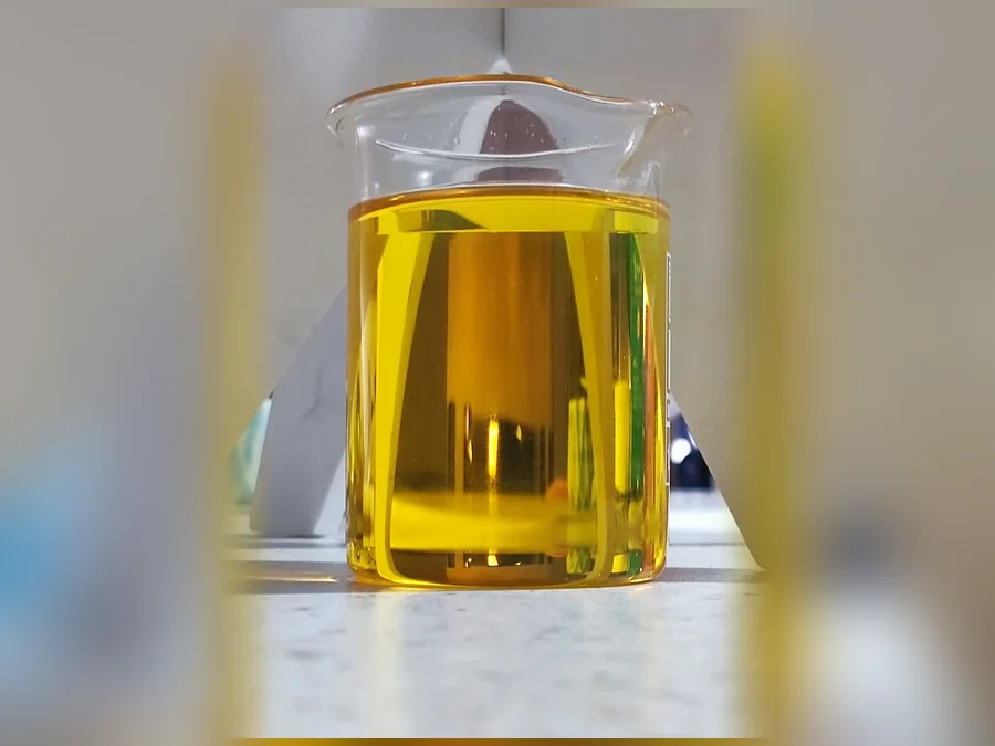 Recycled base oil SN150, clear yellow oil in a laboratory beaker