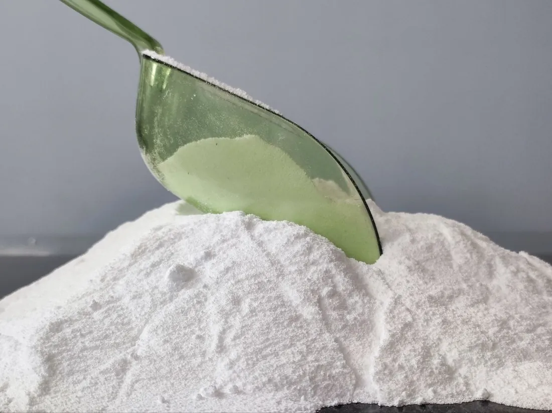 Soda ash (sodium carbonate) white powder in a green scoop