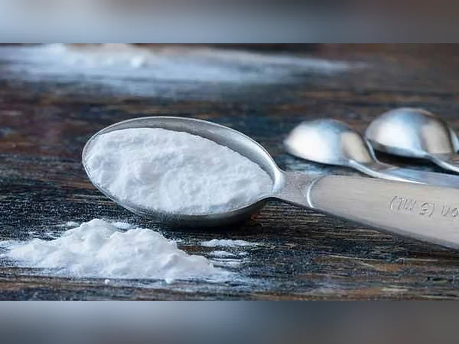 Food-grade sodium bicarbonate (baking soda) powder in a measuring spoon